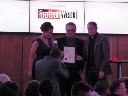 Jason receives the award on stage.